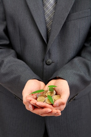 Young businessman with coins and plant isolated on white
の写真素材