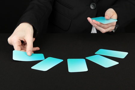 Hand with business cards. Concept: Business like poker game. Isolated on black