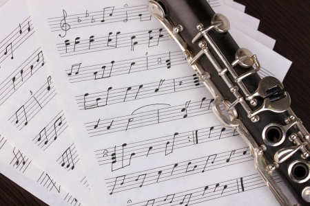 Musical notes and clarinet on wooden tableの写真素材