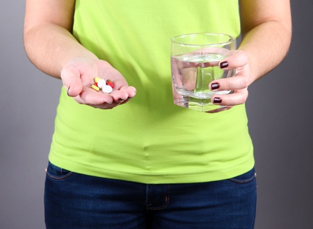 Many pills and glass water in handの写真素材