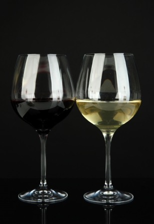 Two glasses of  red and white wine, isolated on blackの写真素材