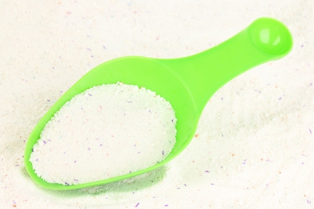 Washing powder in measuring cup on powder backgroundの写真素材