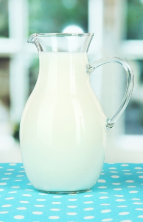 Pitcher of milk on table in roomの写真素材
