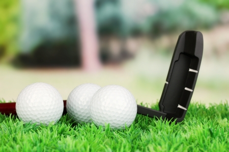 Golf balls and driver on green grass outdoor close upの写真素材