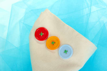Three buttons on beige and blue cloth