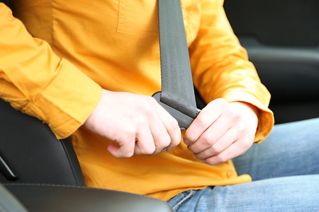 Woman attaching seat belt in the car, close upの写真素材