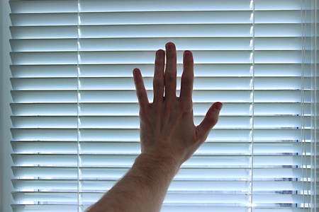 Hand on white blinds backgroundの写真素材