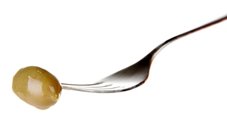 Canned plum sticking on fork, isolated on whiteの写真素材