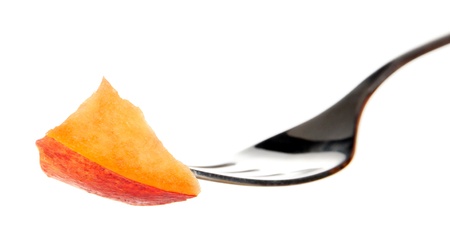 Nectarine piece on fork, isolated on whiteの写真素材