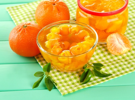 Orange jam with zest and tangerines on wooden desk on wooden tableの写真素材