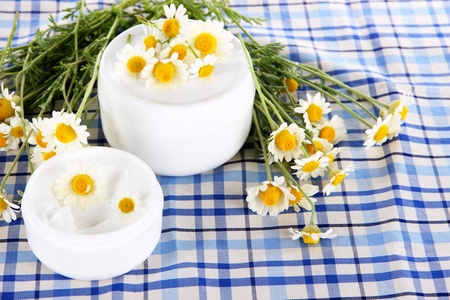Cream with chamomile on checkered cloth backgroundの写真素材