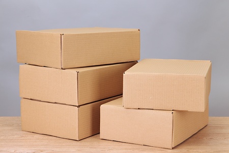 Parcels boxes on wooden table, on grey background