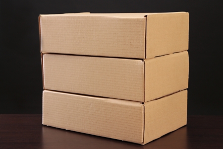 Parcels boxes on wooden table, on black backgroundの写真素材