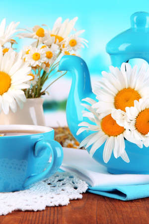 Beautiful bouquet chamomiles in teapot on wooden table on natural backgroundの写真素材