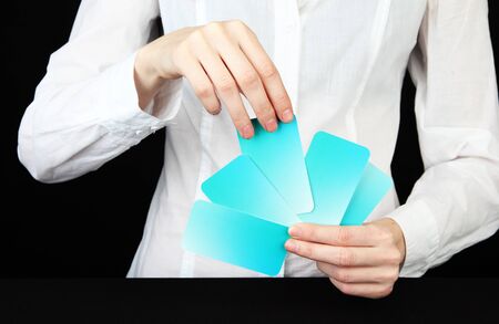 Hand with business cards. Concept: Business like poker game. Isolated on black