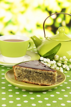 Delicious poppy seed cake with cup of tea on table on bright backgroundの写真素材