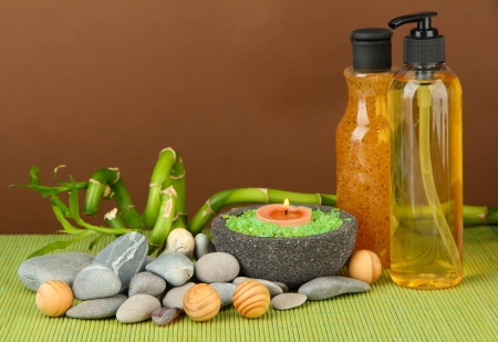 Still life with green bamboo plant and stones, on bamboo mat on color backgroundの写真素材