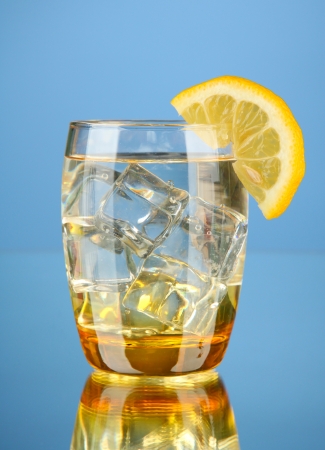 Glass of water and ice on blue backgroundの写真素材