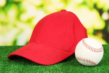 Red peaked cap on grass on natural backgroundの写真素材
