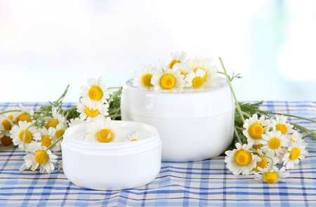 Cream with chamomile on checkered cloth on room backgroundの写真素材