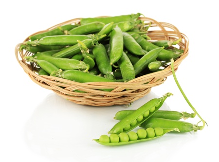 Sweet green peas in wicker basket isolated on whiteの写真素材