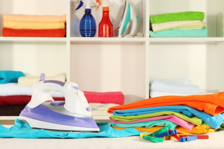 Clothes and iron on table on shelves backgroundの写真素材