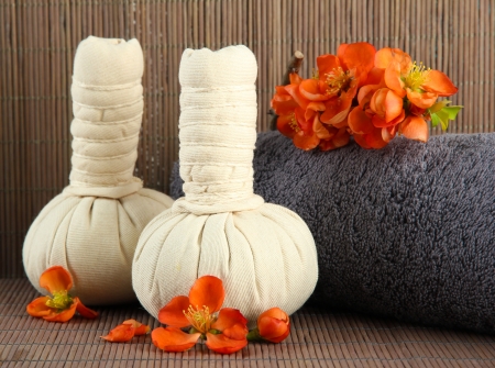 Herbal compress balls for spa treatment  and towel on bamboo backgroundの写真素材