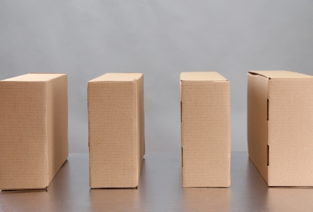 Cardboard boxes on conveyor belt, on grey backgroundの写真素材