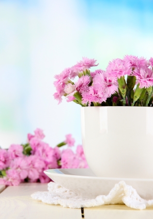 Many small pink cloves in cup on wooden table on window  backgroundの写真素材