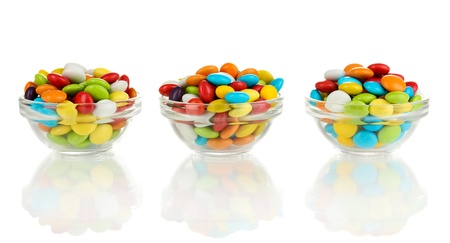 Colorful candies in glass bowls isolated on whiteの写真素材