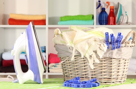 Clothes and iron on table on shelves backgroundの写真素材