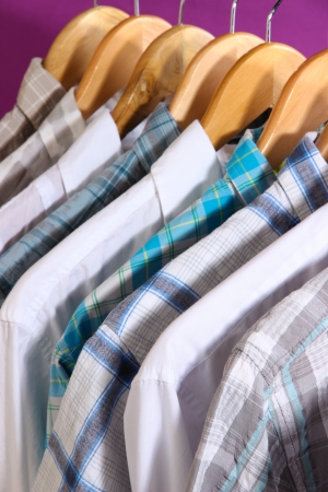 Men's shirts on hangers on purple backgroundの写真素材