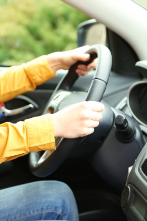 Female hands over a wheel in the car, close upの写真素材