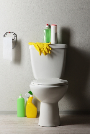 White toilet bowl and  cleaning supplies in a bathroomの写真素材
