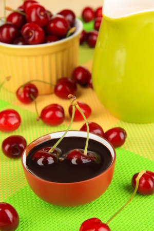 Ripe red cherry berries in bowl on wooden table close-upの写真素材