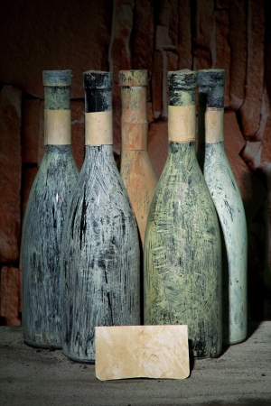 Old bottles of wine in old cellar, on dark  backgroundの写真素材