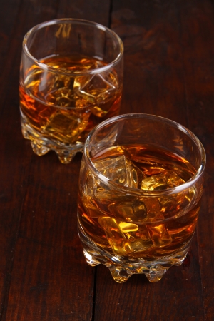 Brandy glasses with ice on wooden backgroundの写真素材