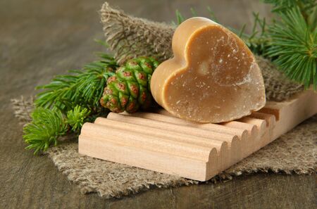 Hand-made soap and green pine cones on wooden backgroundの写真素材