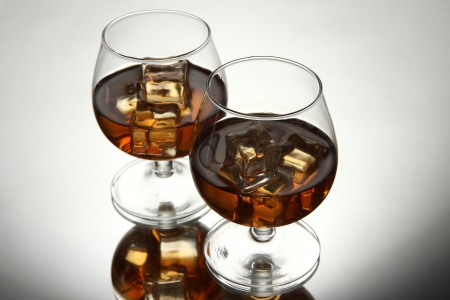 Brandy glasses with ice on grey backgroundの写真素材