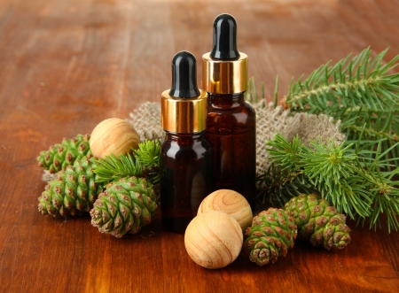 Bottles of fir tree oil and green cones on wooden backgroundの写真素材