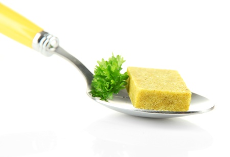 Bouillon cube with parsley on spoon, isolated on whiteの写真素材