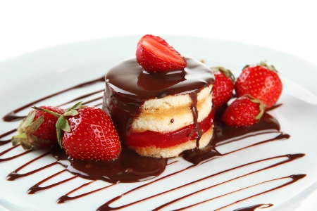 Tasty biscuit cake with chocolate and berries on plate, isolated on whiteの写真素材
