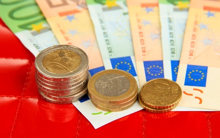 Euro banknotes and euro cents on red backgroundの写真素材