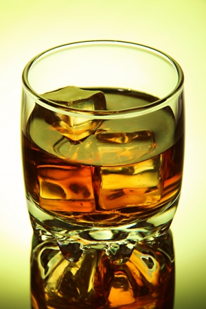 Brandy glass with ice on green backgroundの写真素材