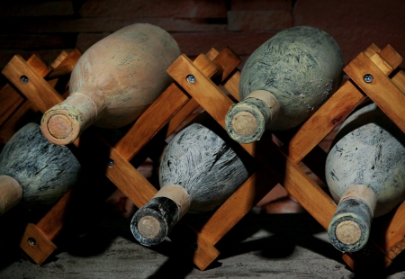 Old bottles of wine in old cellar, on dark  background