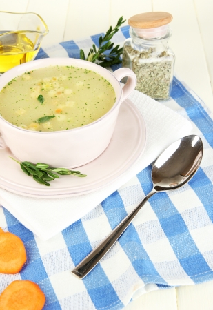 Nourishing soup in pink pan on wooden table close-upの写真素材