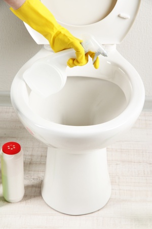 Woman hand with spray bottle cleaning a toilet bowl in a bathroomの写真素材