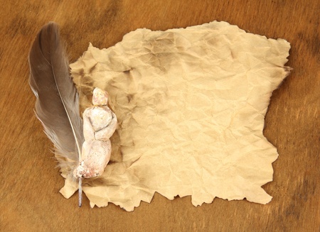 Old paper with figurine, on wooden backgroundの写真素材