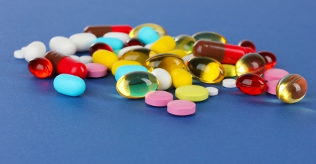 Assortment of pills, tablets and capsules on blue backgroundの写真素材