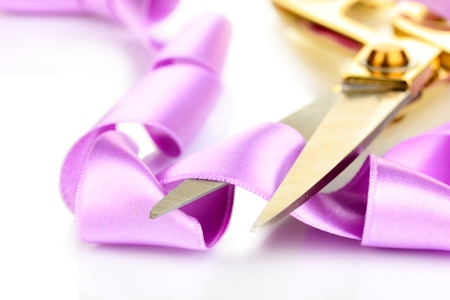Satin ribbon curled around scissors isolated on whiteの写真素材